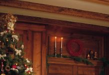 Ghid pentru un Crăciun Retro: Cum să alegi și să decorezi cel mai frumos brad artificial Brad artificial premium in stil vintage decorat cu globuri auriu antichizat si cupru, intr-un living retro cu atmosfera calda de Craciun.