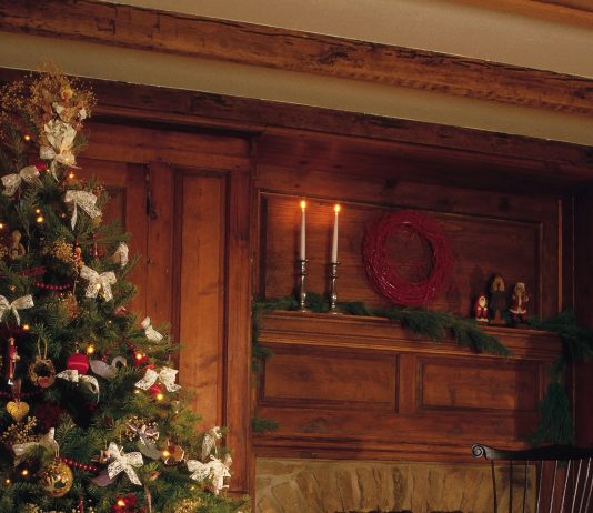 Ghid pentru un Crăciun Retro: Cum să alegi și să decorezi cel mai frumos brad artificial Brad artificial premium in stil vintage decorat cu globuri auriu antichizat si cupru, intr-un living retro cu atmosfera calda de Craciun.